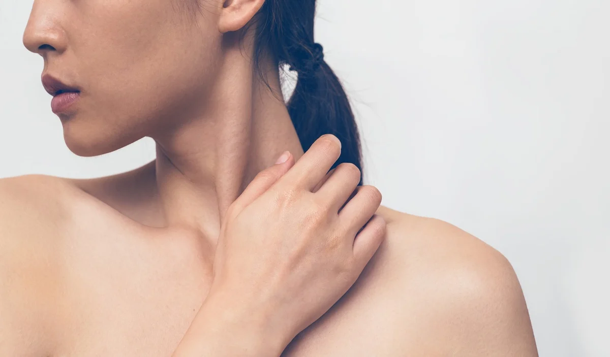 Woman touching neck showing smooth hydrated skin