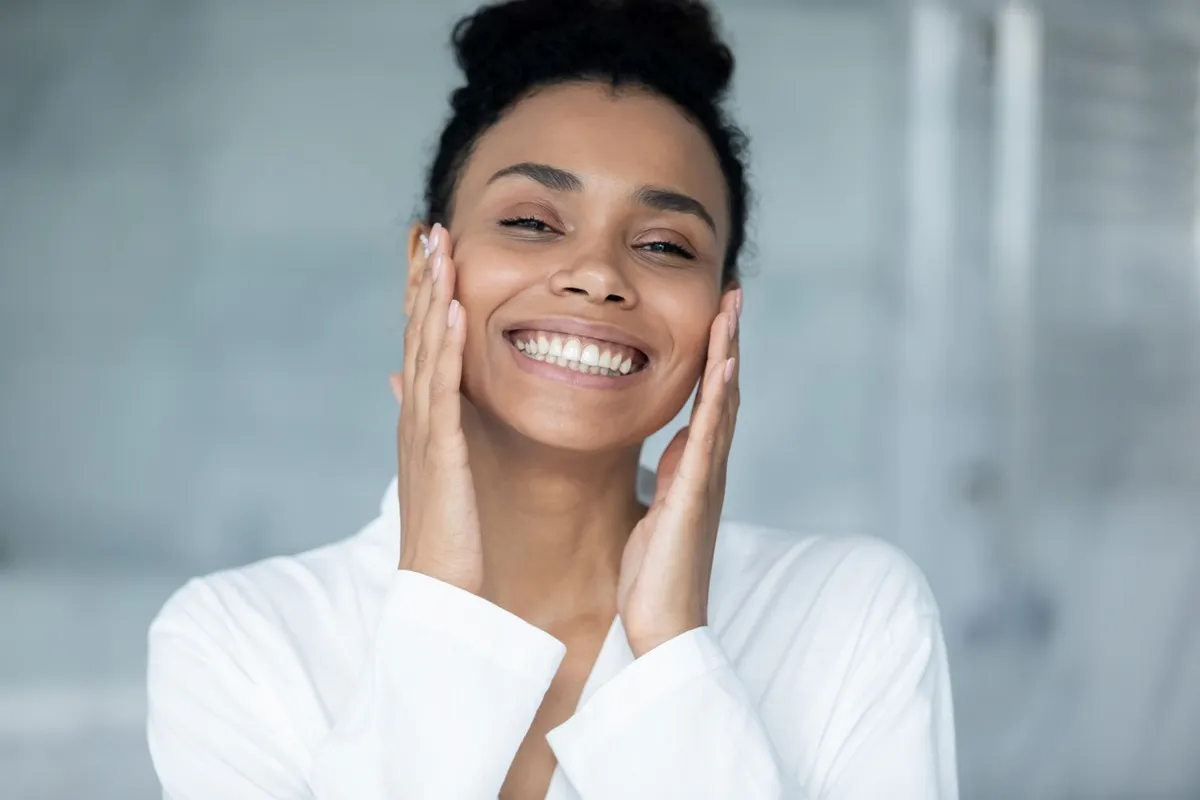 Woman smiling with glowing skin after facial treatment