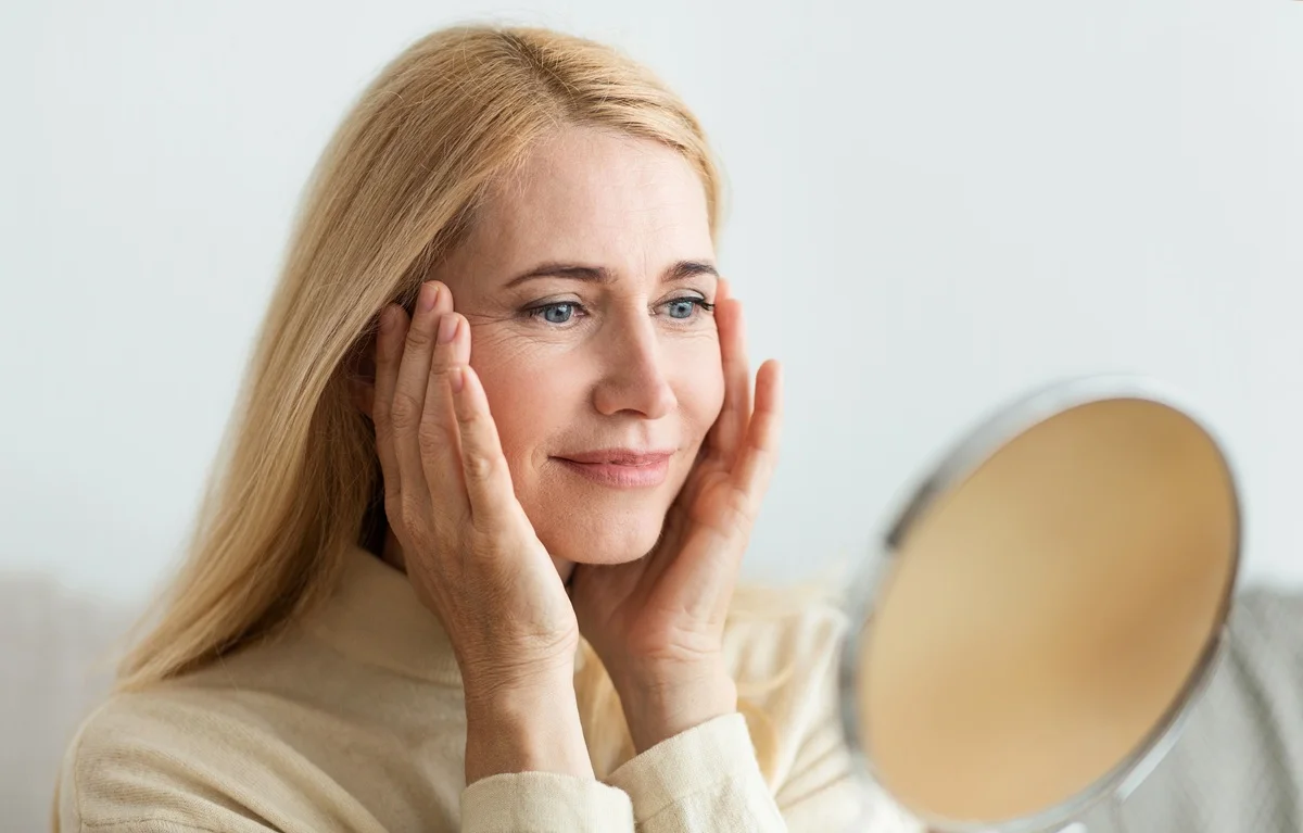 Woman touching face showing healthy glowing skin
