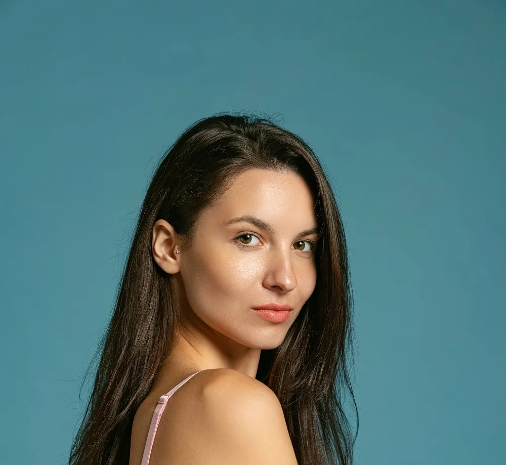 Beauty portrait with teal background highlighting healthy skin