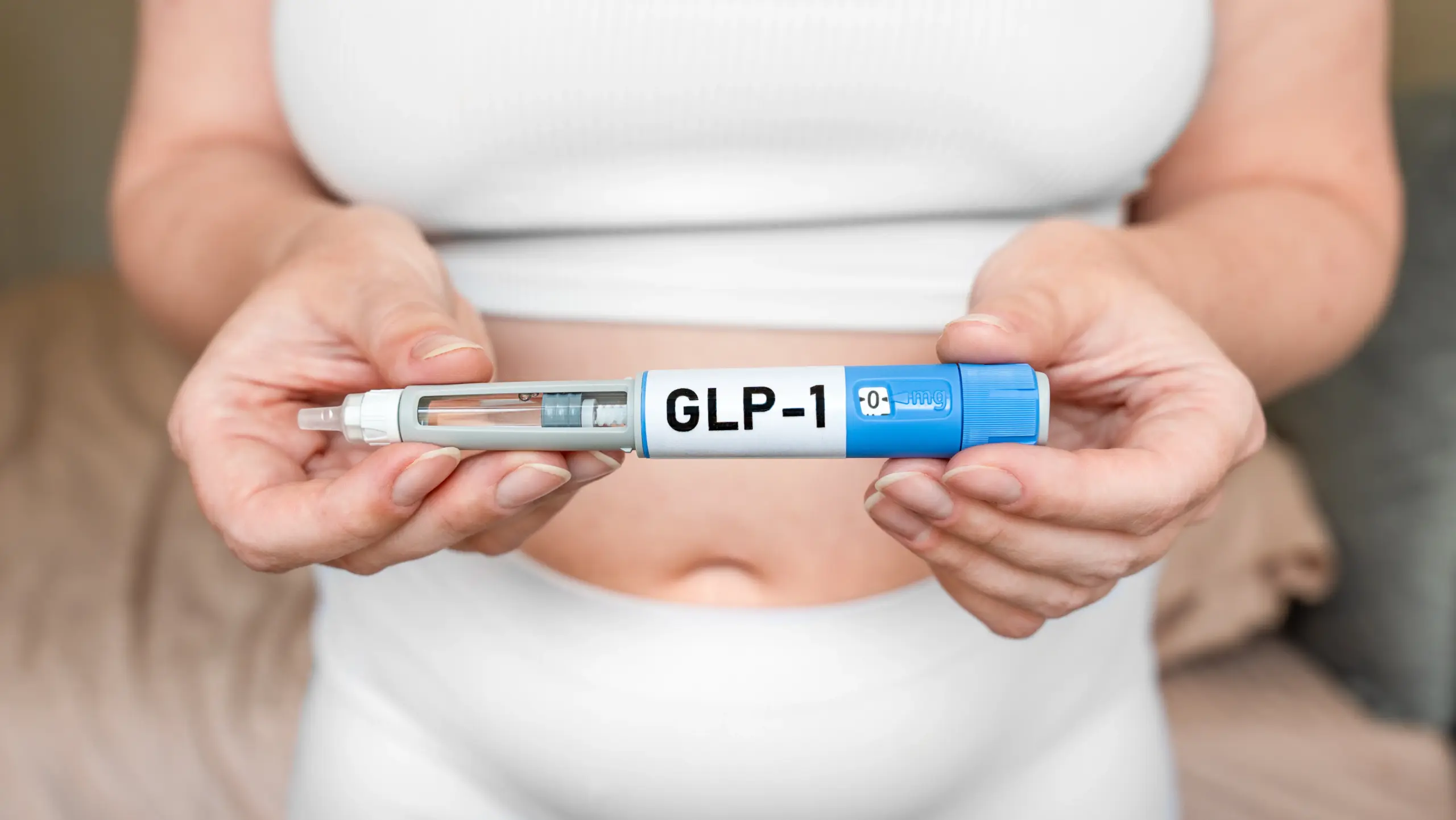 GLP-1 weight loss treatment medication pen shown in hands